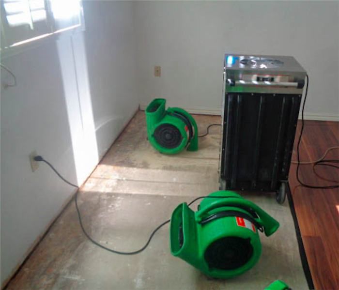 Air movers and dehumidifier on floor.