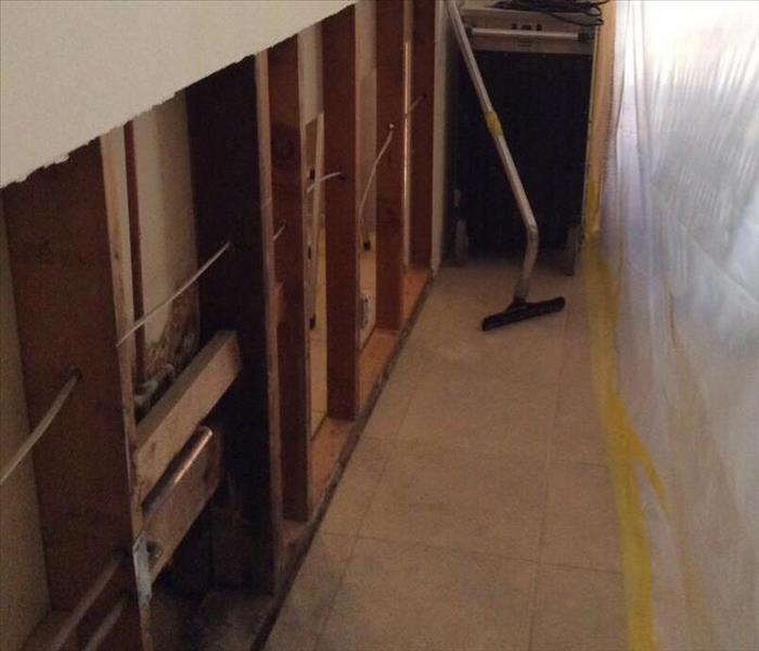 Wall framing exposed with containment and a vacuum attachment against the wall