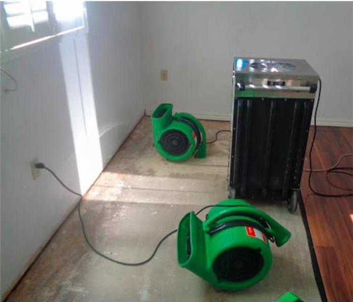 Specialist machines are cleaning water damage in a home.