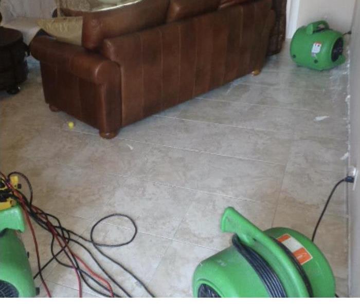 Restoration machines are cleaning water damage in a home.