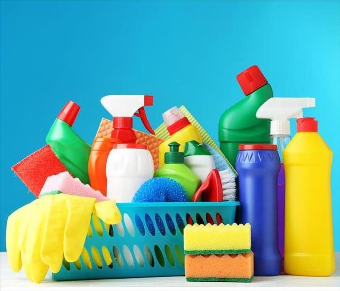 Bottles with detergent and cleaning tools on blue background