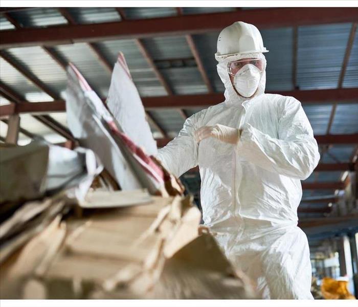 A person wearing googles, white helmet and a white suite as a protective gear against flooding water